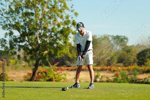 Professinal golf player on golf course. Pro golfer taking a shot