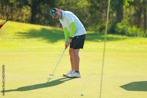 Professinal golf player on golf course. Pro golfer taking a shot