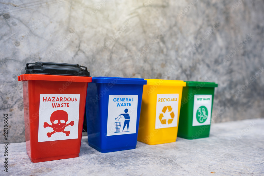 The concept of waste classification for recycling. Collection of bins for different types of garbage by separation according to the color of the bin with old wall background. The concept of waste classification for recycling. Collection of bins for different types of garbage by separation according to the color of the bin with old wall background.