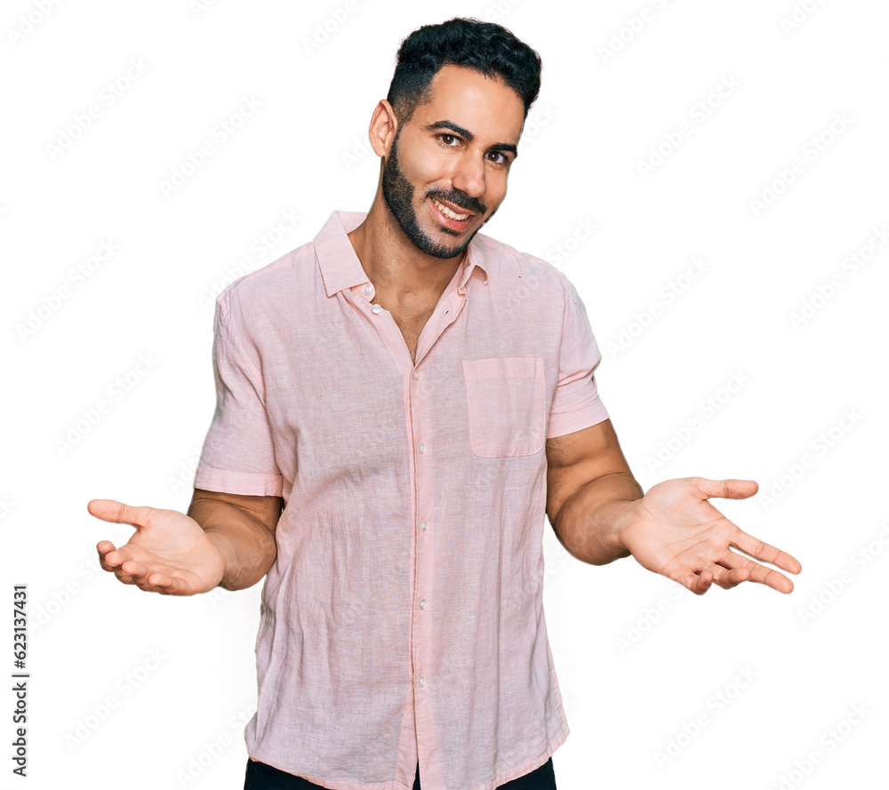 Hispanic man with beard wearing casual shirt clueless and confused expression with arms and hands raised. doubt concept. Hispanic man with beard wearing casual shirt clueless and confused expression with arms and hands raised. doubt concept.