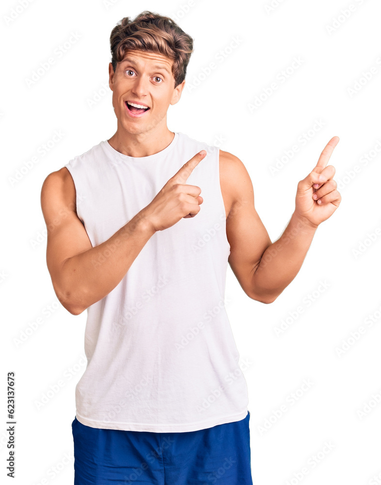 Young handsome man wearing sleveeless t shirt smiling and looking at the camera pointing with two hands and fingers to the side. Young handsome man wearing sleveeless t shirt smiling and looking at the camera pointing with two hands and fingers to the side.