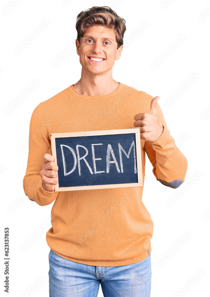 Young handsome man holding blackboard with dream word smiling happy and positive, thumb up doing excellent and approval sign Young handsome man holding blackboard with dream word smiling happy and positive, thumb up doing excellent and approval sign