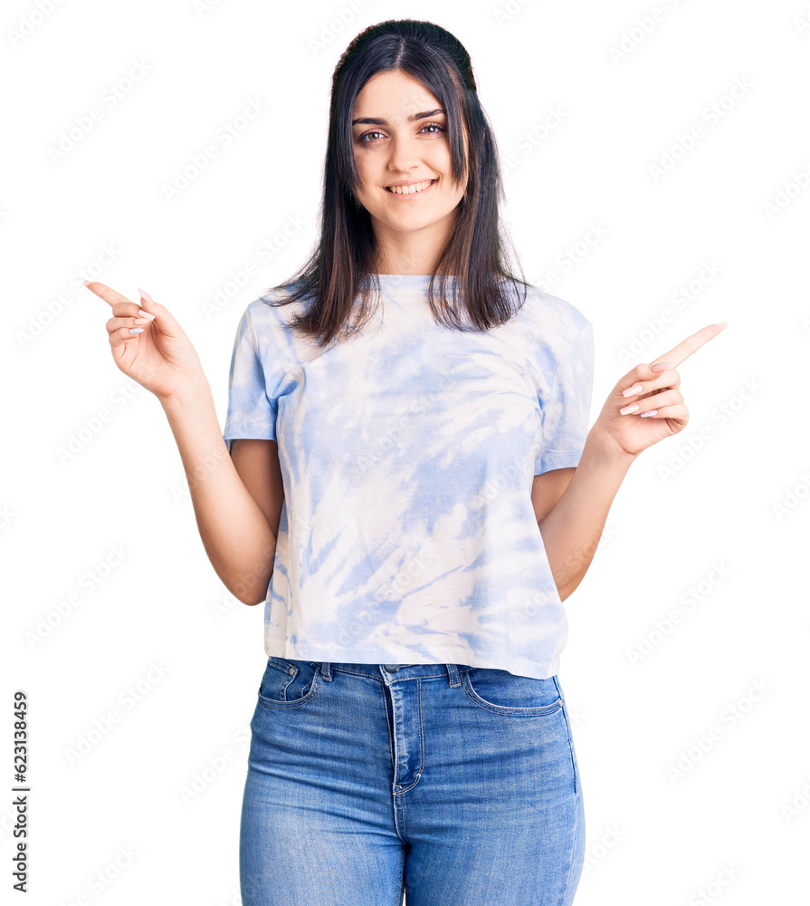 Young beautiful girl wearing casual t shirt smiling confident pointing with fingers to different directions. copy space for advertisement Young beautiful girl wearing casual t shirt smiling confident pointing with fingers to different directions. copy space for advertisement