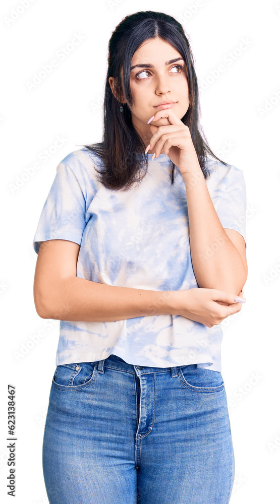 Young beautiful girl wearing casual t shirt with hand on chin thinking about question, pensive expression. smiling with thoughtful face. doubt concept. Young beautiful girl wearing casual t shirt with hand on chin thinking about question, pensive expression. smiling with thoughtful face. doubt concept.