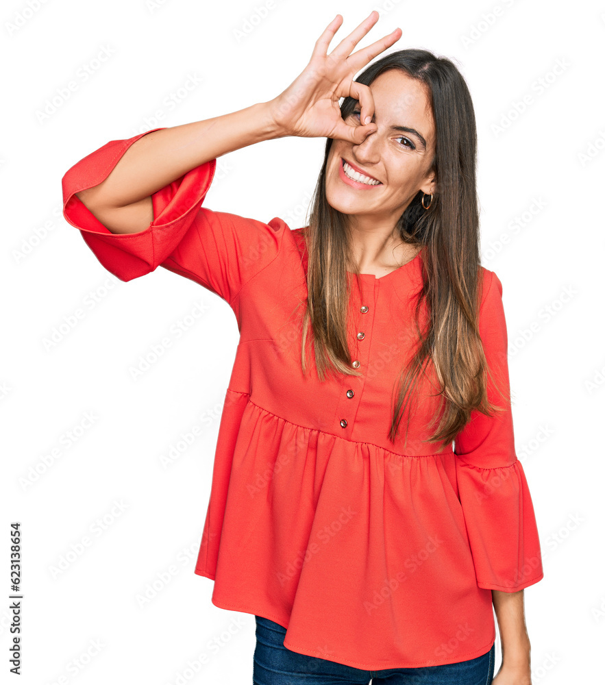 Young beautiful woman wearing casual clothes smiling happy doing ok sign with hand on eye looking through fingers Young beautiful woman wearing casual clothes smiling happy doing ok sign with hand on eye looking through fingers