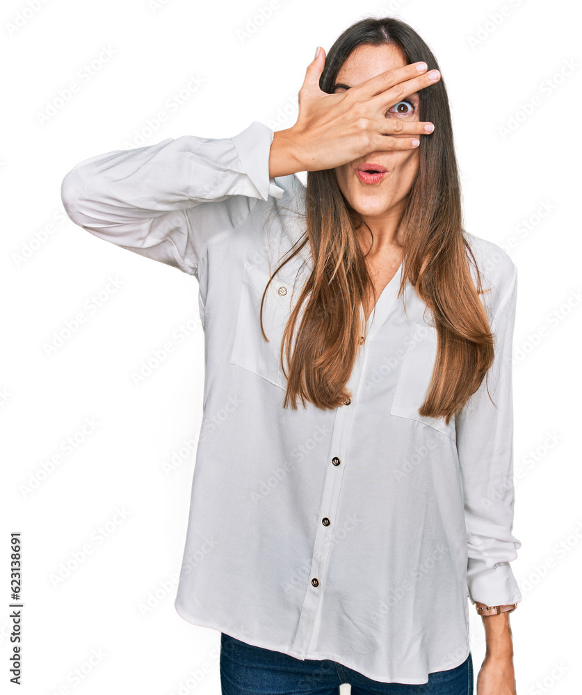 Young beautiful woman wearing casual clothes peeking in shock covering face and eyes with hand, looking through fingers with embarrassed expression. Young beautiful woman wearing casual clothes peeking in shock covering face and eyes with hand, looking through fingers with embarrassed expression.