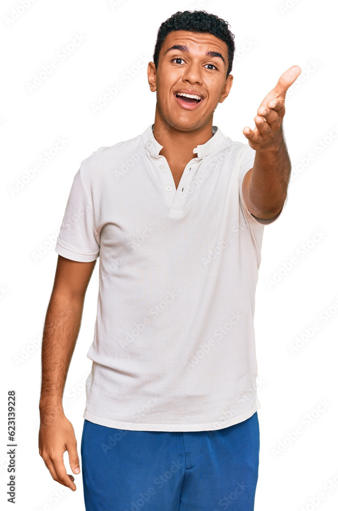 Young arab man wearing casual clothes smiling friendly offering handshake as greeting and welcoming. successful business. Young arab man wearing casual clothes smiling friendly offering handshake as greeting and welcoming. successful business.