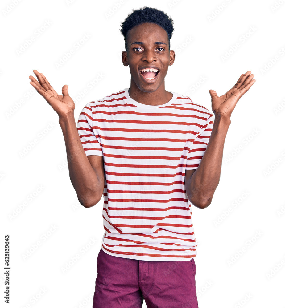 Young african american man wearing casual clothes celebrating crazy and amazed for success with arms raised and open eyes screaming excited. winner concept Young african american man wearing casual clothes celebrating crazy and amazed for success with arms raised and open eyes screaming excited. winner concept