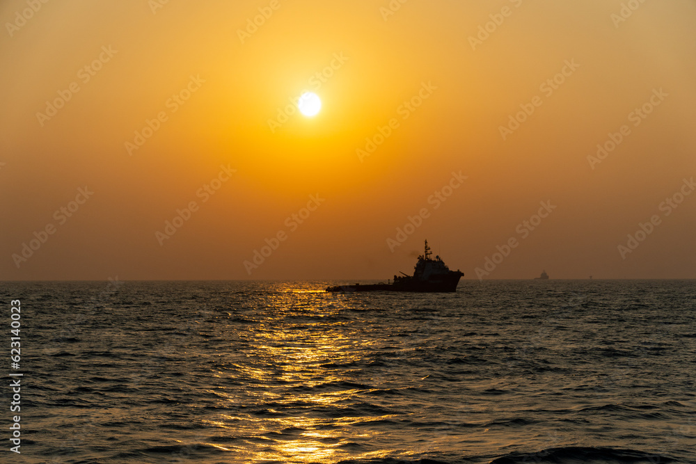 sunset creating ship silhouette offshore