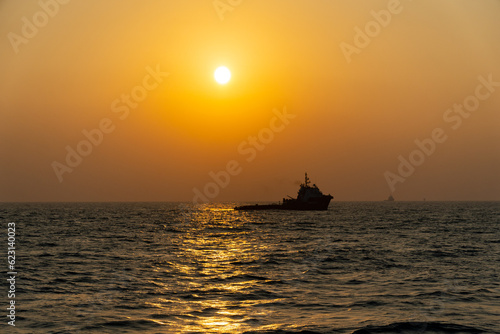 sunset creating ship silhouette offshore © Reza