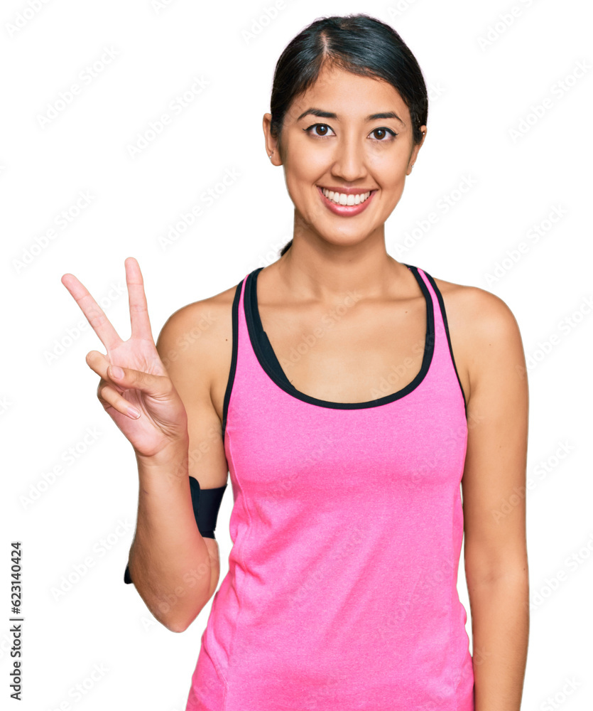 Beautiful asian young sport woman wearing sportswear and arm band showing and pointing up with fingers number two while smiling confident and happy. Beautiful asian young sport woman wearing sportswear and arm band showing and pointing up with fingers number two while smiling confident and happy.