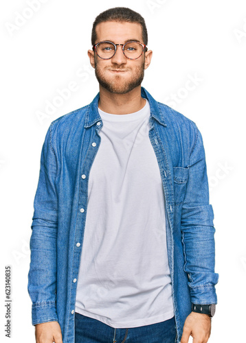 Young caucasian man wearing casual clothes puffing cheeks with funny face. mouth inflated with air, crazy expression.