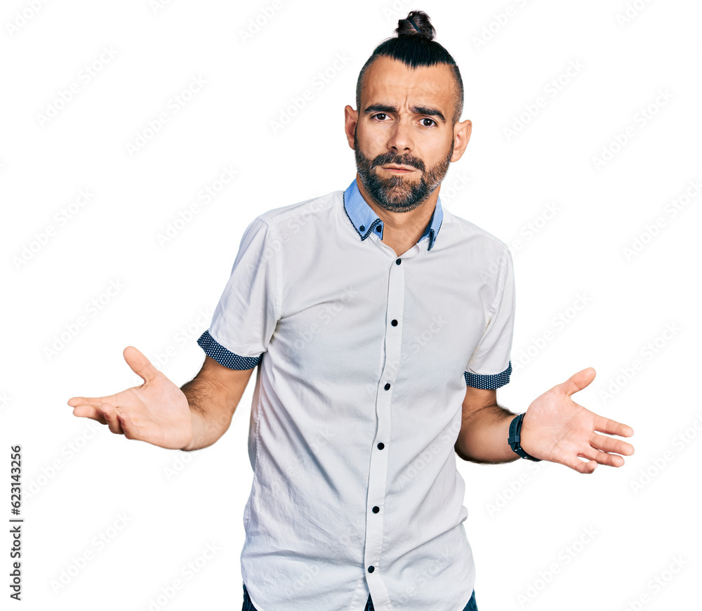Hispanic man with ponytail wearing casual white shirt clueless and confused with open arms, no idea concept. Hispanic man with ponytail wearing casual white shirt clueless and confused with open arms, no idea concept.