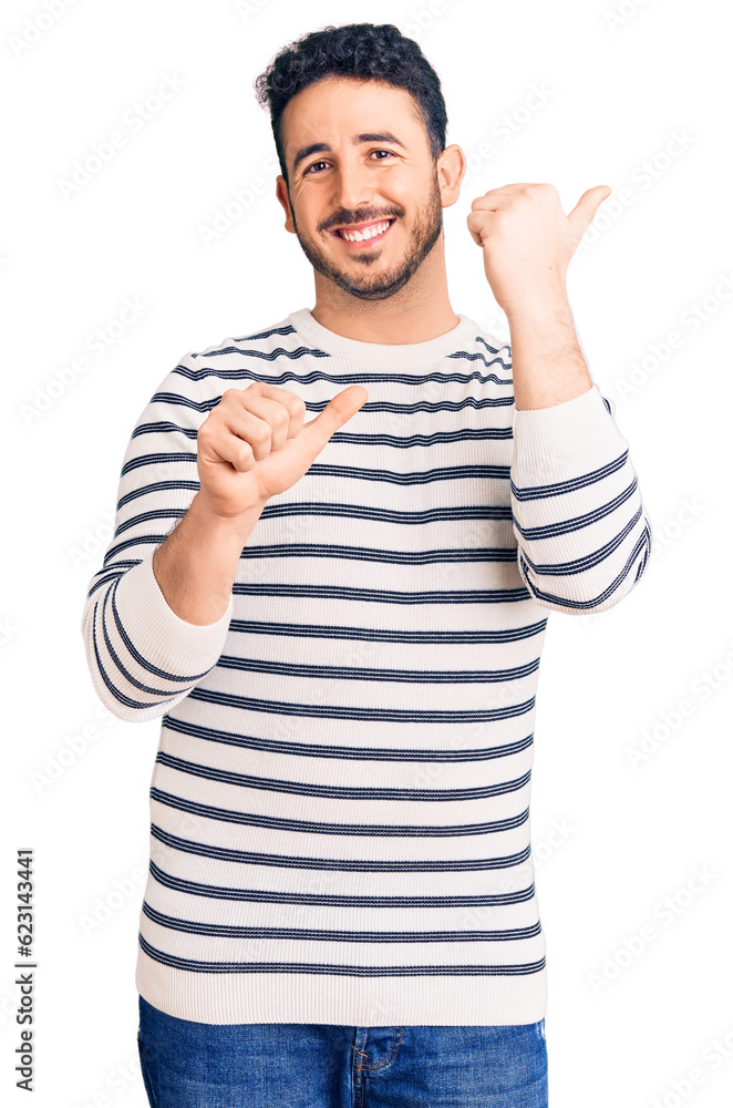 Young hispanic man wearing casual clothes pointing to the back behind with hand and thumbs up, smiling confident Young hispanic man wearing casual clothes pointing to the back behind with hand and thumbs up, smiling confident