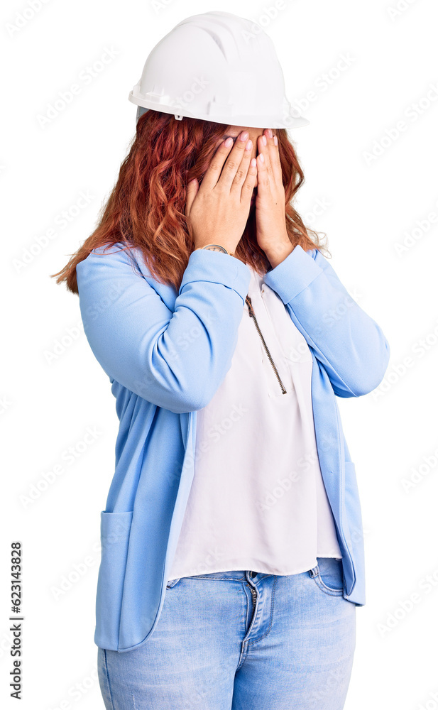 Young latin woman wearing architect hardhat with sad expression covering face with hands while crying. depression concept. Young latin woman wearing architect hardhat with sad expression covering face with hands while crying. depression concept.