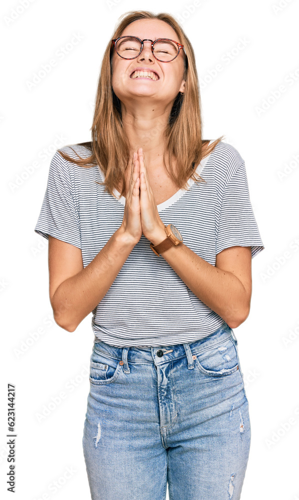 Beautiful young blonde woman wearing casual clothes and glasses begging and praying with hands together with hope expression on face very emotional and worried. begging. Beautiful young blonde woman wearing casual clothes and glasses begging and praying with hands together with hope expression on face very emotional and worried. begging.