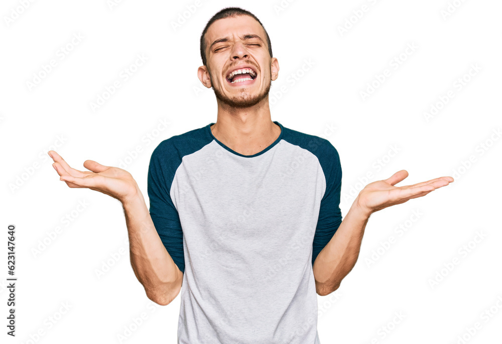 Fototapeta premium Hispanic young man wearing casual clothes celebrating mad and crazy for success with arms raised and closed eyes screaming excited. winner concept