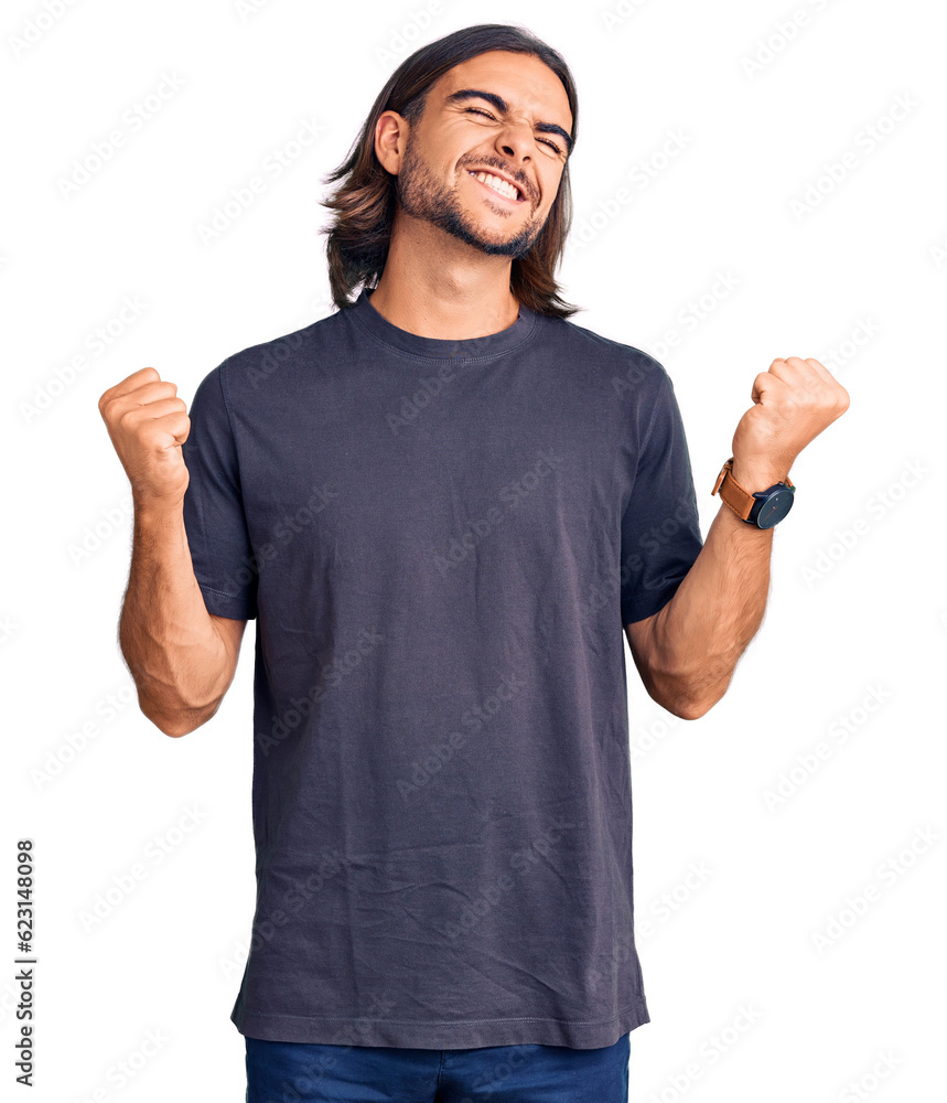 Fototapeta premium Young handsome man wearing casual clothes very happy and excited doing winner gesture with arms raised, smiling and screaming for success. celebration concept.