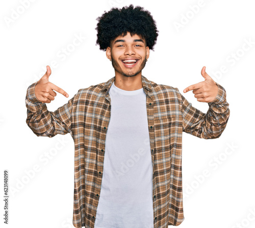 Young african american man with afro hair wearing casual clothes looking confident with smile on face, pointing oneself with fingers proud and happy.