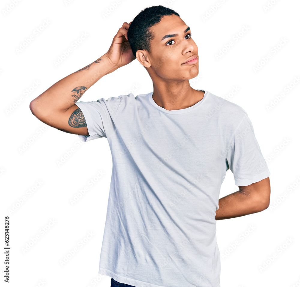 Young hispanic man wearing casual white t shirt confuse and wondering about question. uncertain with doubt, thinking with hand on head. pensive concept. Young hispanic man wearing casual white t shirt confuse and wondering about question. uncertain with doubt, thinking with hand on head. pensive concept.