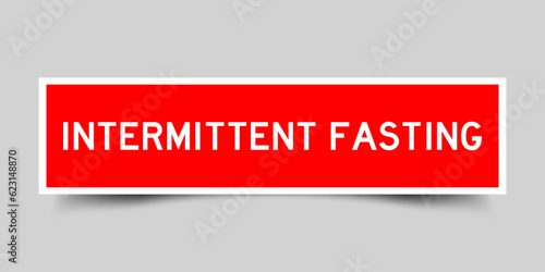Red color square shape sticker label with word intermittent fasting on gray background