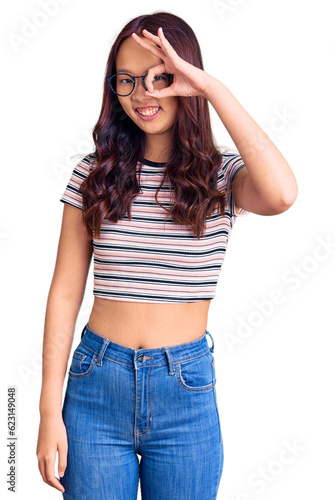 Young beautiful chinese girl wearing casual clothes smiling happy doing ok sign with hand on eye looking through fingers