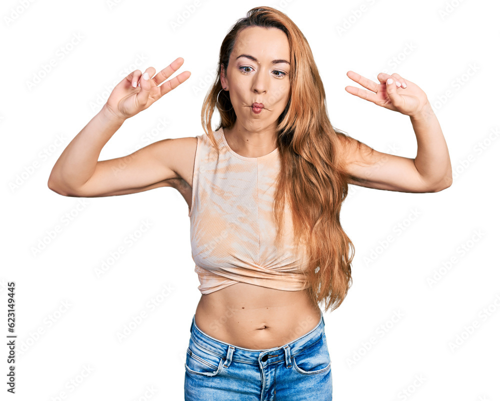 Young caucasian woman doing victory sign and peace gesture making fish face with mouth and squinting eyes, crazy and comical. Young caucasian woman doing victory sign and peace gesture making fish face with mouth and squinting eyes, crazy and comical.