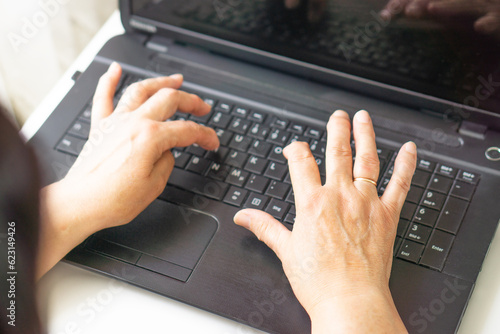Female hands typing on a keyboard laptop computer. Business, education and programming concept.