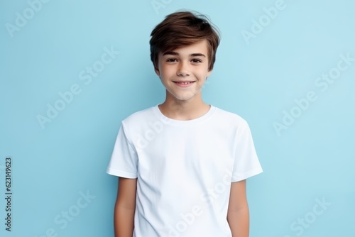 a photo of a young model kid boy with a blank white canvas t-shirt. pastel blue wall background. Generative AI