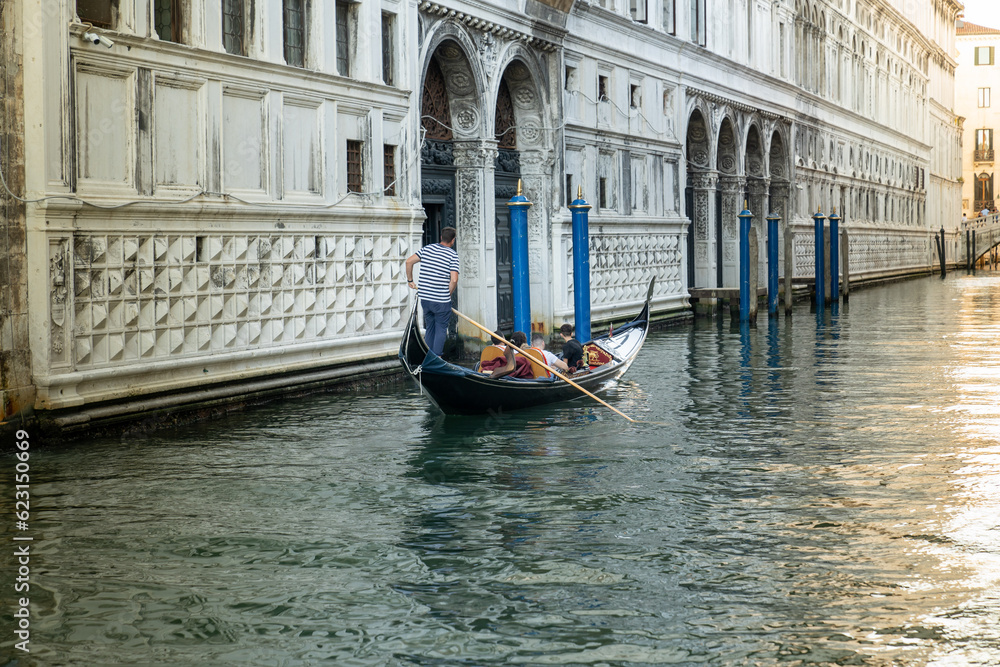 Traveling with a traditional gondola through the narrow ancient canals of Venice (Venedik) italy.