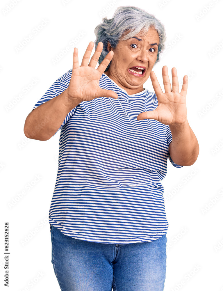 Senior woman with gray hair wearing casual striped clothes afraid and terrified with fear expression stop gesture with hands, shouting in shock. panic concept. Senior woman with gray hair wearing casual striped clothes afraid and terrified with fear expression stop gesture with hands, shouting in shock. panic concept.
