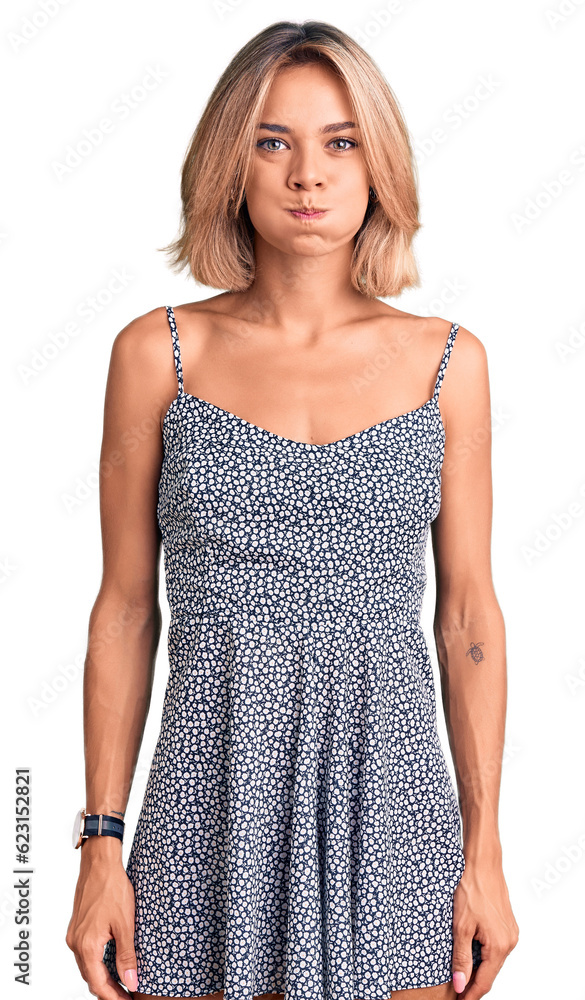 Beautiful caucasian woman wearing summer dress puffing cheeks with funny face. mouth inflated with air, crazy expression. Beautiful caucasian woman wearing summer dress puffing cheeks with funny face. mouth inflated with air, crazy expression.
