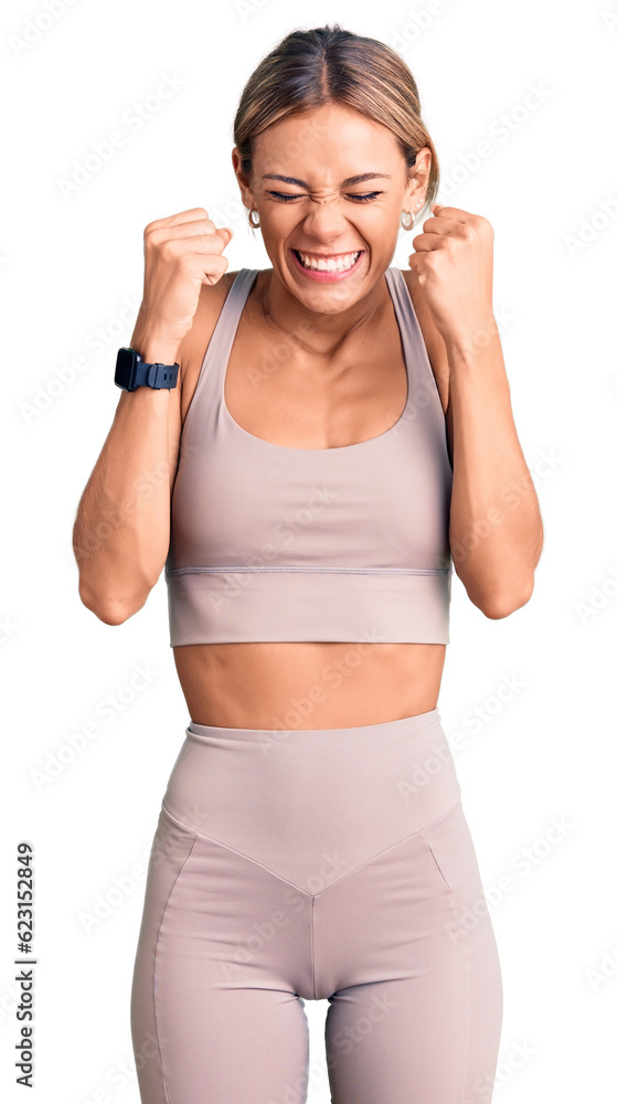 Beautiful caucasian woman wearing sportswear excited for success with arms raised and eyes closed celebrating victory smiling. winner concept. Beautiful caucasian woman wearing sportswear excited for success with arms raised and eyes closed celebrating victory smiling. winner concept.