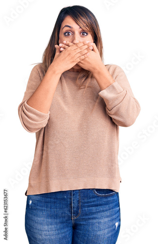 Young beautiful woman wearing casual sweater shocked covering mouth with hands for mistake. secret concept.