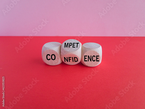 Competence and Confidence symbol. Businessman hand points at wooden cubes with words Confidence and Competence. Beautiful pink background, red table. Business concept. Copy space