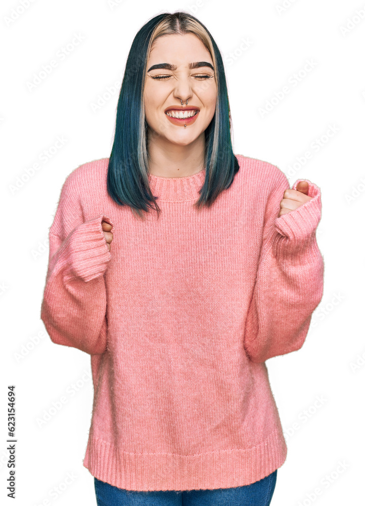 Young modern girl wearing pink wool winter sweater excited for success with arms raised and eyes closed celebrating victory smiling. winner concept. Young modern girl wearing pink wool winter sweater excited for success with arms raised and eyes closed celebrating victory smiling. winner concept.