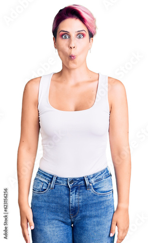 Young beautiful woman with pink hair wearing casual clothes making fish face with lips  crazy and comical gesture. funny expression.
