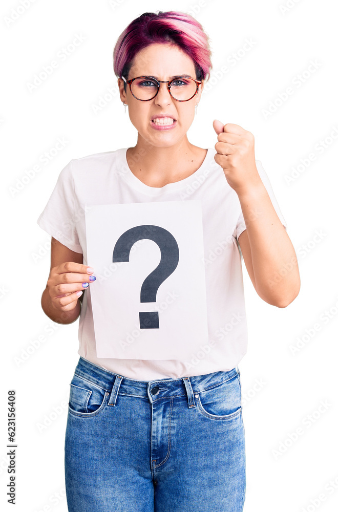 Young beautiful woman with pink hair holding question mark annoyed and frustrated shouting with anger, yelling crazy with anger and hand raised Young beautiful woman with pink hair holding question mark annoyed and frustrated shouting with anger, yelling crazy with anger and hand raised