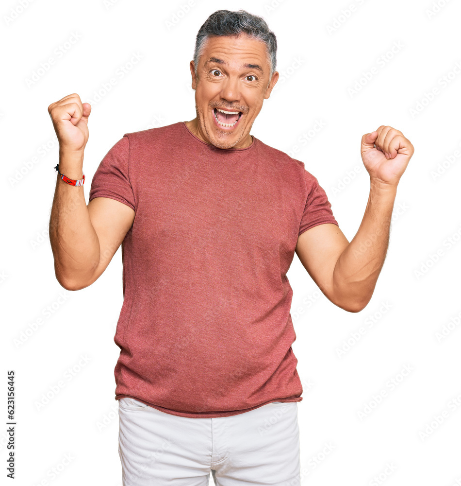Handsome middle age man wearing casual clothes screaming proud, celebrating victory and success very excited with raised arms Handsome middle age man wearing casual clothes screaming proud, celebrating victory and success very excited with raised arms