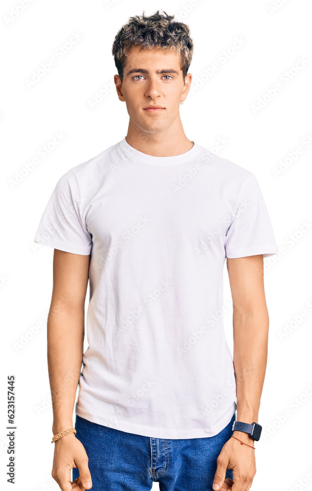 Obraz premium Young handsome man wearing casual white tshirt relaxed with serious expression on face. simple and natural looking at the camera.