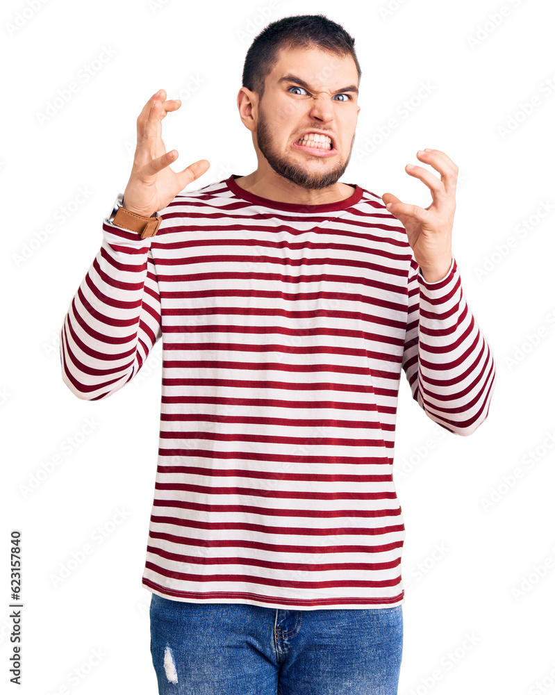 Young handsome man wearing striped sweater shouting frustrated with rage, hands trying to strangle, yelling mad Young handsome man wearing striped sweater shouting frustrated with rage, hands trying to strangle, yelling mad