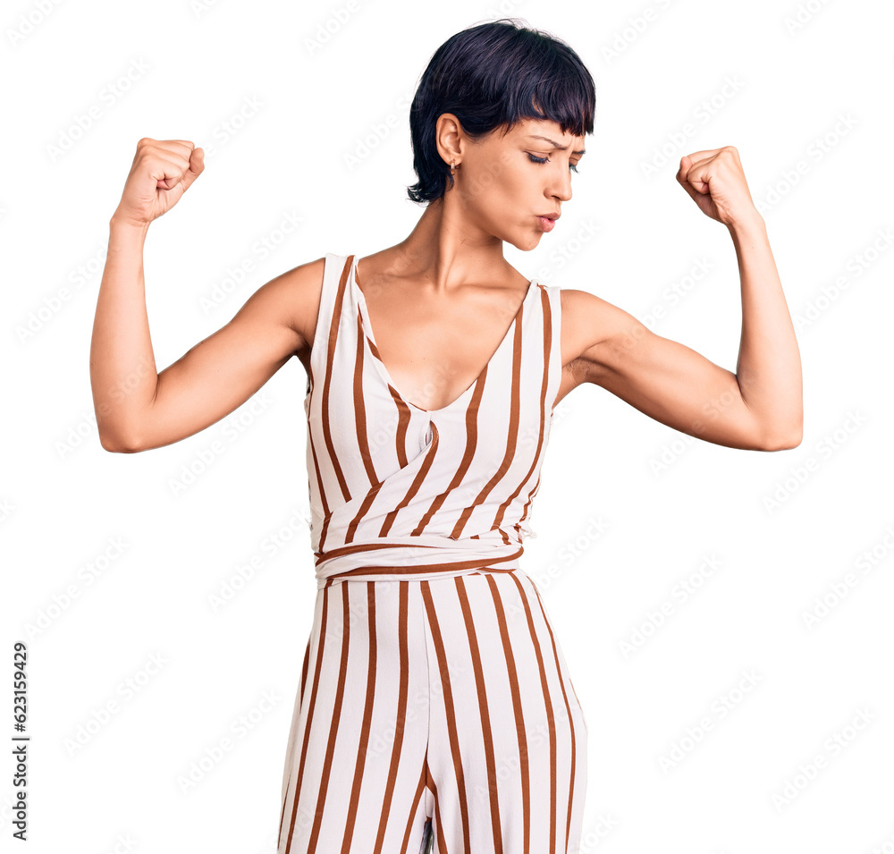 Young brunette woman with short hair wearing summer outfit showing arms muscles smiling proud. fitness concept. Young brunette woman with short hair wearing summer outfit showing arms muscles smiling proud. fitness concept.