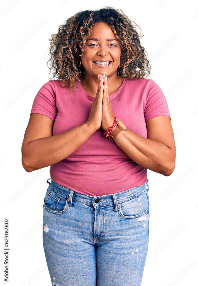 Young african american plus size woman wearing casual clothes praying with hands together asking for forgiveness smiling confident. Young african american plus size woman wearing casual clothes praying with hands together asking for forgiveness smiling confident.