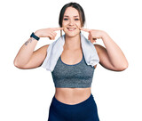 Young hispanic girl wearing sportswear and towel smiling cheerful showing and pointing with fingers teeth and mouth. dental health concept.