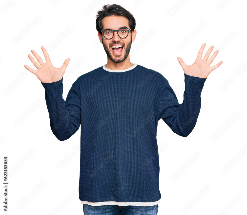 Young hispanic man wearing casual clothes and glasses showing and pointing up with fingers number ten while smiling confident and happy. Young hispanic man wearing casual clothes and glasses showing and pointing up with fingers number ten while smiling confident and happy.