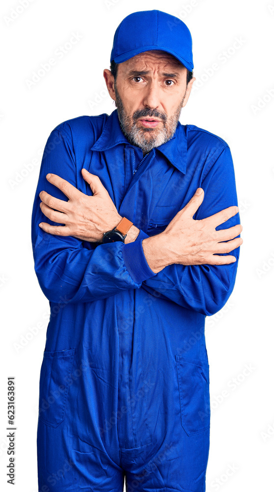 Middle age handsome man wearing mechanic uniform shaking and freezing for winter cold with sad and shock expression on face Middle age handsome man wearing mechanic uniform shaking and freezing for winter cold with sad and shock expression on face