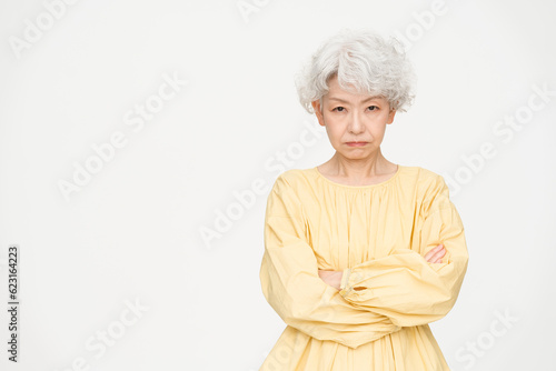 グレーヘアの健康的な日本人シニア女性/スタジオ撮影白背景/怒っている