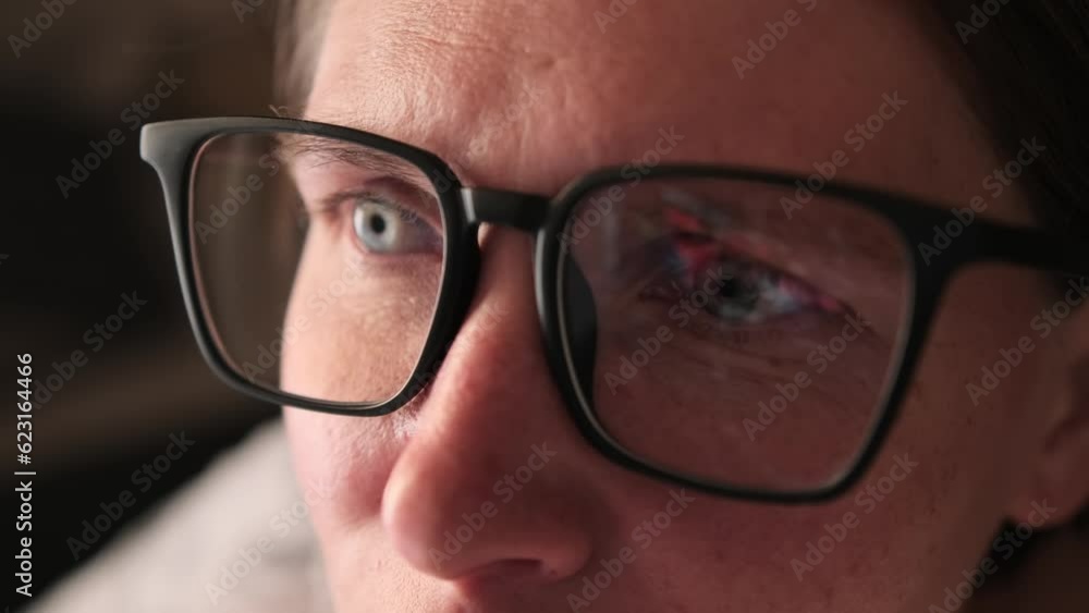 Reflection in eyeglasses woman of an abstract animation of financial charts on monitor display, macro. Trading report for business concept. Close-up of girl in glasses studying financial markets. Reflection in eyeglasses woman of an abstract animation of financial charts on monitor display, macro. Trading report for business concept. Close-up of girl in glasses studying financial markets.