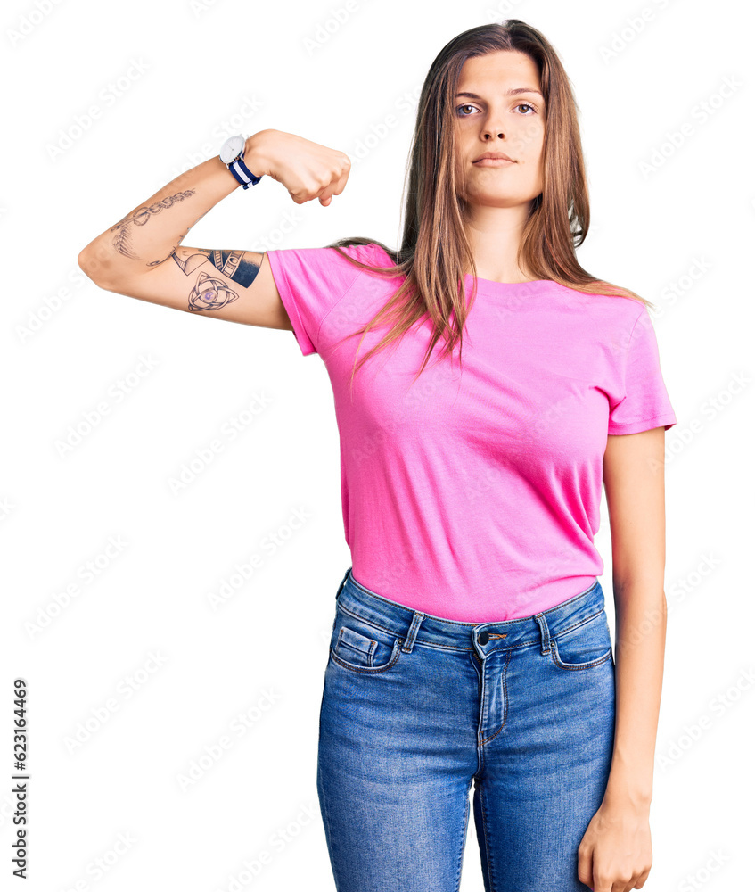 Fototapeta premium Beautiful caucasian woman wearing casual clothes strong person showing arm muscle, confident and proud of power