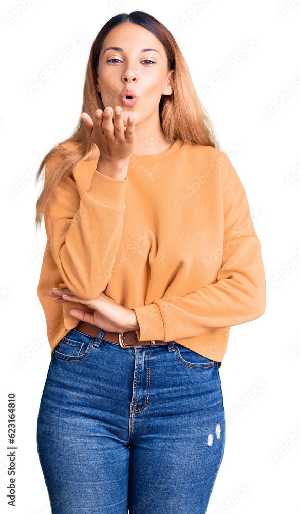 Beautiful young woman wearing casual clothes looking at the camera blowing a kiss with hand on air being lovely and sexy. love expression. Beautiful young woman wearing casual clothes looking at the camera blowing a kiss with hand on air being lovely and sexy. love expression.
